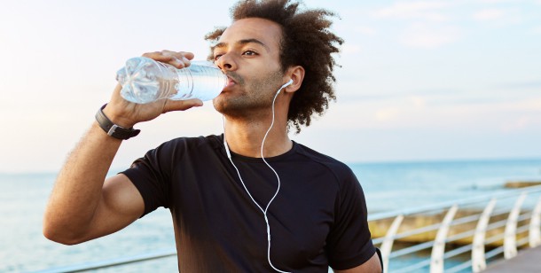 A man takes a break from exercising to drink some water in Houston, TX