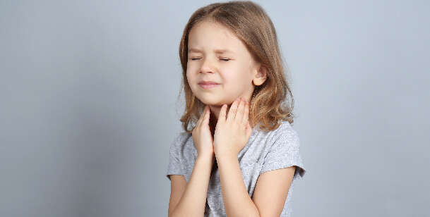 girl holding sore throat in Houston, TX