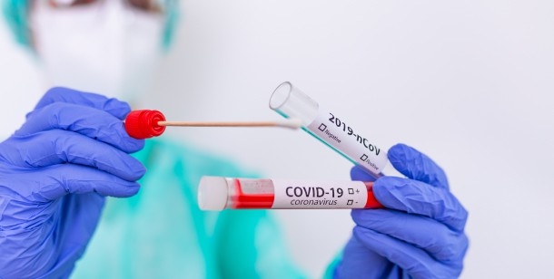 A doctor holds a COVID-19 test kit at an emergency room in Houston, TX