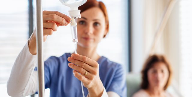 A nurse prepares an IV for a dehydrated woman at a Houston, TX emergency room