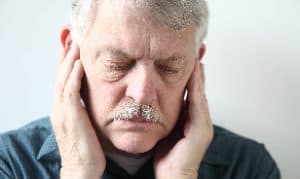 A man holding both ears in pain due in Houston, TX