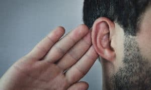 A man holding one hand next to his ear in Houston, TX