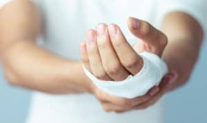 A person holding their bandaged hand at an emergency room in Houston, TX