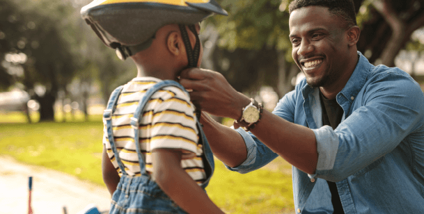 A father puts a helmet on his son for a bike ride in Houston, TX