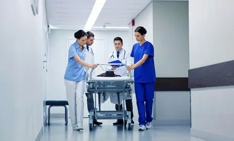 Doctors wheel a gurney through an emergency room in Houston, TX