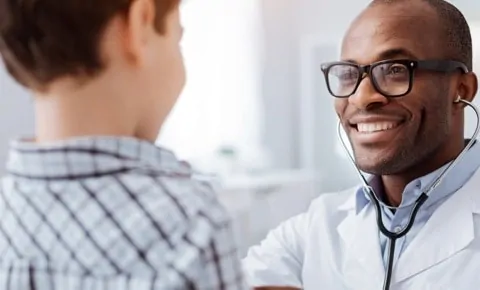 A pediatrician talking to a little boy at an emergency room in Houston, TX