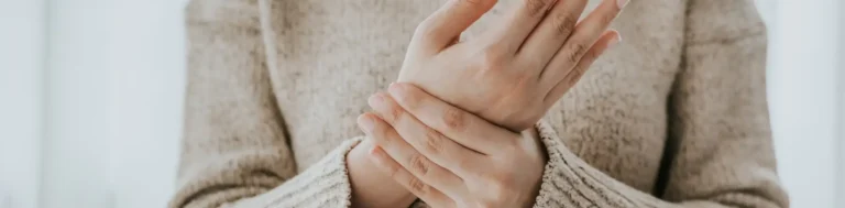 A close-up of a woman with tendonitis holding her wrist in Houston, TX.