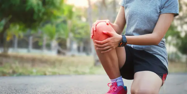 Person stretching their hurting knee in Houston, TX