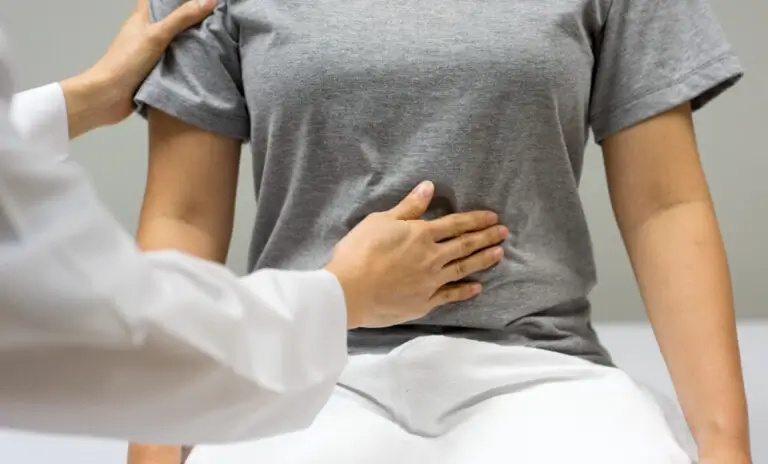 A doctor presses their hand to a woman's abdomen at a Houston, TX emergency room. 