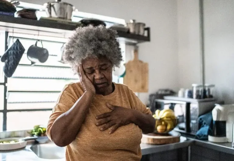 A woman with shortness of breath stands in her Houston, TX kitchen